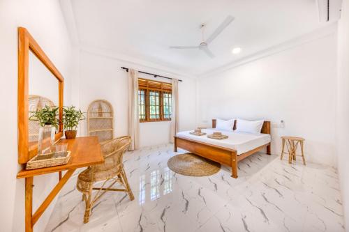 阿杭格默MAKAI Surf House的白色的客房配有书桌和床。