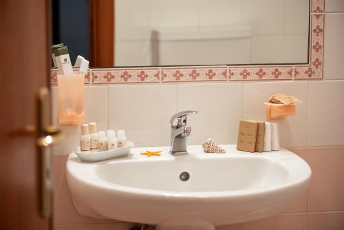 斯蓬加诺Relais Casina Copini的浴室内的盥洗盆和镜子