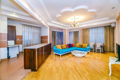 巴库Deluxe Apartment 142/43的客厅配有蓝色的沙发和桌子