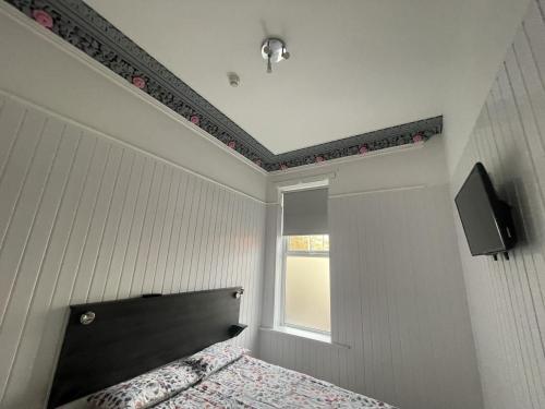 贝尔法斯特OYO Queens Quarter的一间卧室配有一张带黑色床头板的床和窗户