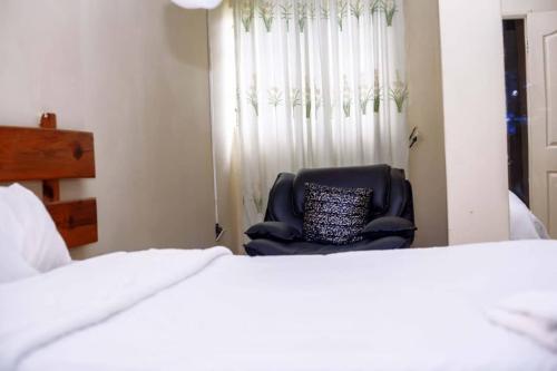 ChongweWhite Lotus Lodges Katete的卧室内的椅子,带窗户和床