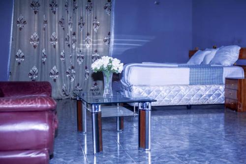 ChongweWhite Lotus Lodges Katete的一间卧室配有一张床和一张鲜花桌子