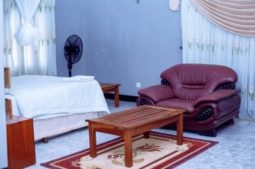 ChongweWhite Lotus Lodges Katete的一间卧室配有沙发、椅子和一张床