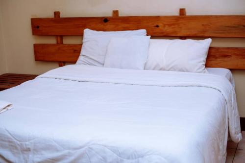 ChongweWhite Lotus Lodges Katete的一张白色大床,配有白色床单和枕头