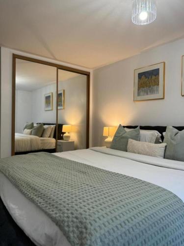 达特福德Stunning 2-Bed Apartment in Dartford的一间卧室设有一张大床和一个大镜子