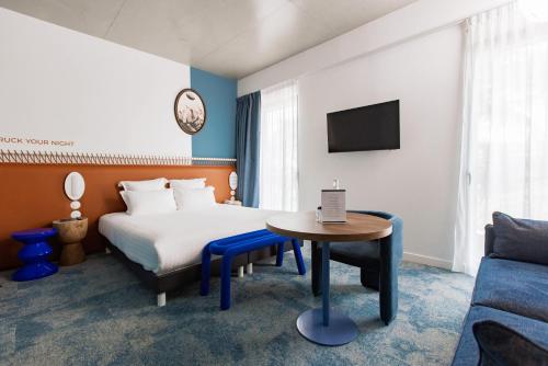 里昂The Ruck Hotel的酒店客房配有床、桌子和沙发。