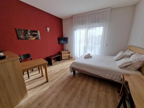 迪沃讷莱班Appartement confortable - Proche du lac的一间卧室配有一张床、一张书桌和一个窗户。