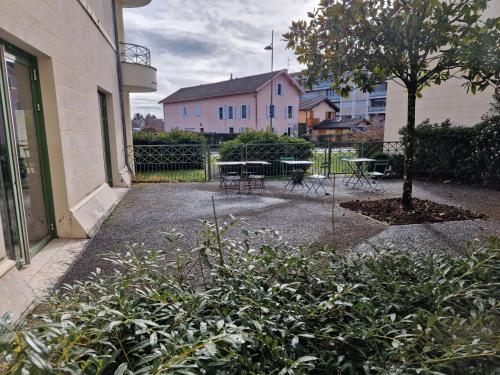 迪沃讷莱班Appartement confortable - Proche du lac的庭院,有桌子和一棵树,还有一座建筑