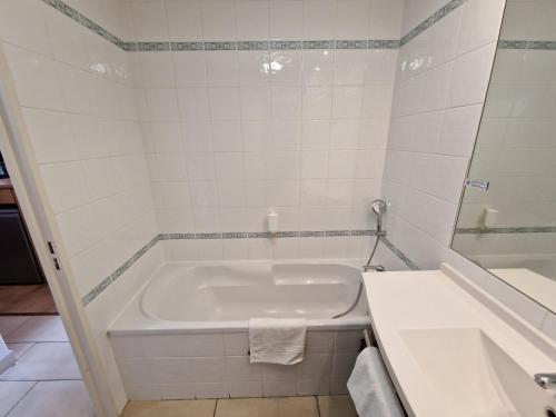 迪沃讷莱班Appartement confortable - Proche du lac的白色的浴室设有浴缸和水槽。