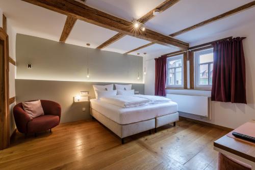 福尔卡赫DAS HOCHREIN的卧室配有一张白色大床和一把椅子