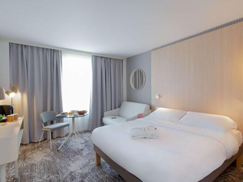 普罗旺斯艾克斯诺沃特埃克斯普罗旺斯拉克桥酒店的酒店客房设有一张白色大床和一张书桌