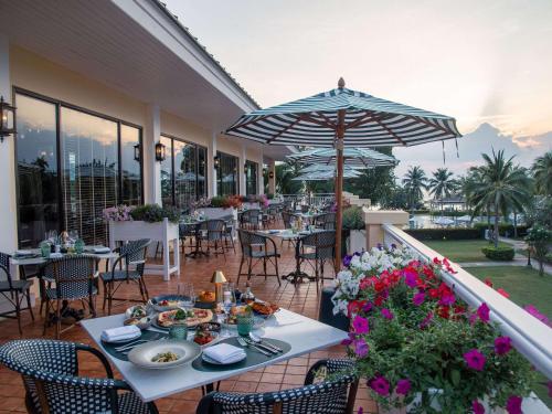功孟海滩Sofitel Krabi Phokeethra Golf and Spa Resort的一个带桌椅和遮阳伞的庭院