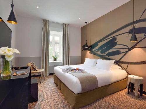 阿尔勒Hôtel & Spa Jules César Arles - MGallery Hotel Collection的酒店客房设有一张大床和一张书桌。
