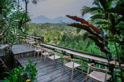 塔巴南Abing Dalem - Villa Durian的山 ⁇ 的木甲板上摆放着一排椅子
