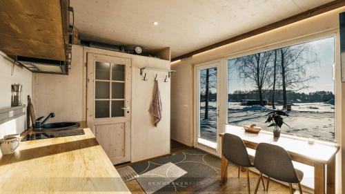 奥泰佩Juusa cabin的厨房配有桌椅和窗户。