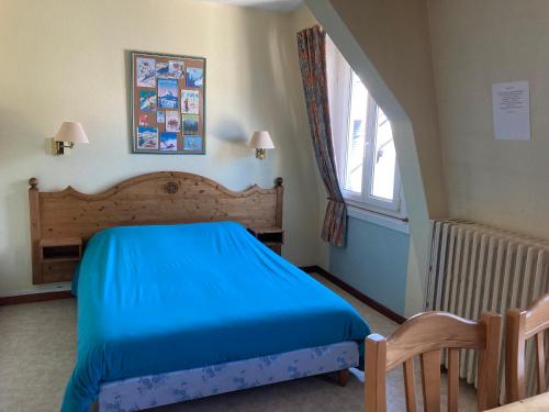圣皮耶尔德沙尔特勒斯Hotel Victoria的一间卧室设有蓝色的床和窗户。