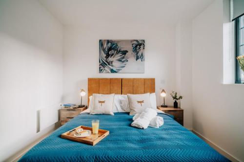 伯明翰Canal view, Grade II Industrial style, Fast WiFi, Family, Contractors的一间卧室配有一张蓝色的床,上面有托盘