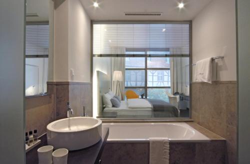 海德堡海德堡艺术酒店的带浴缸的浴室和1间带1张床的卧室