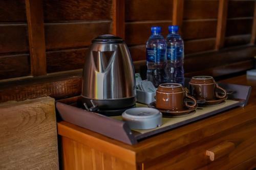 塔巴南Abing Dalem - Villa Mangga的托盘上的咖啡壶,装有杯子和水瓶