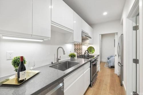 旧金山Charming apt in Pacific Heights的白色的厨房配有水槽和一瓶葡萄酒