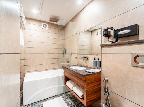 齐拉克普尔Playotel Inn, Chandigarh的带浴缸、卫生间和盥洗盆的浴室