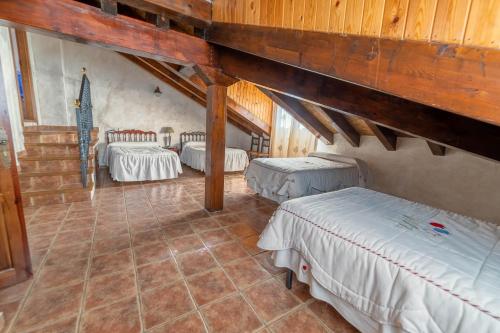 坎塔洛哈斯卡斯蒂略迪埃普瑞斯乡村度假屋的阁楼间设有三张床和楼梯。