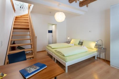 罗拉赫赛本达斯安迪乐酒店的一间卧室设有一张床和一个螺旋楼梯