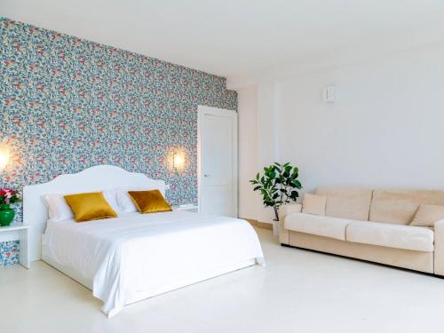塔维亚诺Relais San Martino Salento - Handwritten Collection的白色卧室配有床和沙发