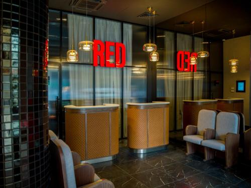 贝尔格莱德Radisson RED Belgrade的窗户上带有红色标志的餐厅