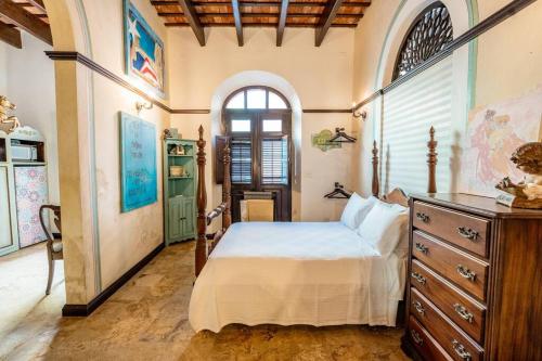 圣胡安Charming Retreat in Old San Juan的一间卧室配有一张床、一个梳妆台和一扇窗户。