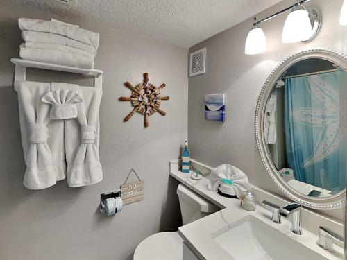 加尔维斯敦Victorian 5302- Oceans Away的浴室配有盥洗池、卫生间和镜子。