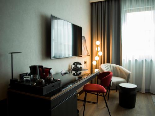 贝尔格莱德Radisson RED Belgrade的酒店客房配有书桌、电视和椅子