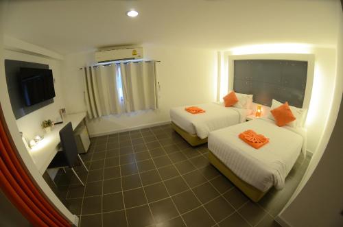 洛坤府橙色原味酒店的酒店客房设有两张床和浴缸。