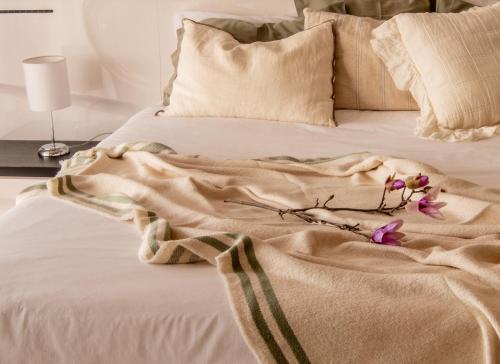 里韦拉布拉瓦Bairos House - Coastal Escape的床上有毯子和鲜花