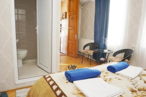 库塔伊西Belas House With Terrace的客房设有两张床和一间带卫生间的浴室。