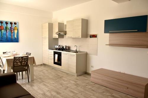 萨尔雷BoaOp Apartaments的厨房配有白色橱柜、餐桌和用餐室