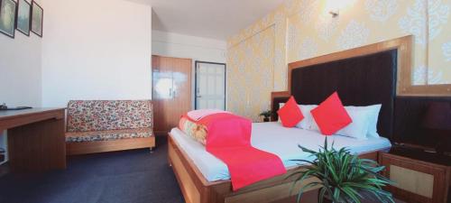 大吉岭Hotel North Point Inn Darjeeling的一间卧室配有一张红色椅子的床
