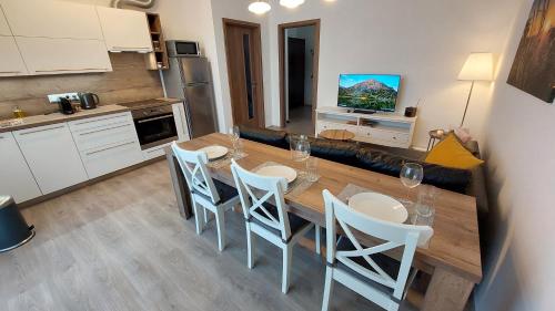 贝龙Apartmán Trilobit的厨房配有木桌和白色椅子