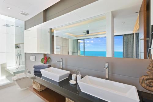 茶云莱海滩Sukkho Samui Estates的一间带两个盥洗盆和大镜子的浴室
