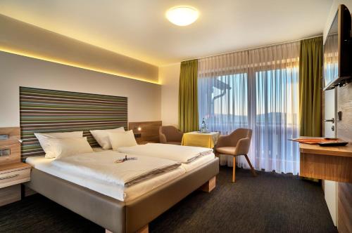 瓦尔德明兴格鲁伯兰德酒店的酒店客房设有一张床和一个大窗户