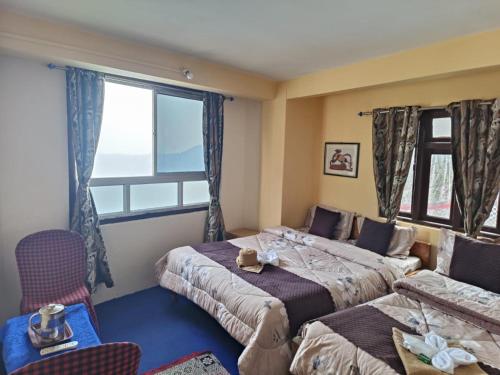 大吉岭GRG Mountview By Darjeeling的一间卧室设有两张床和窗户。