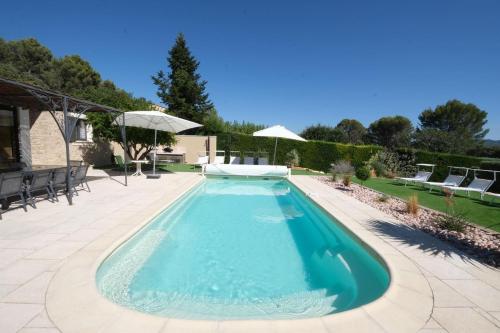 Pugetvery beautiful villa with private pool in the luberon enjoying a magnificent view of the durance valley, located in puget – 10 people.的庭院内的游泳池,配有椅子和遮阳伞