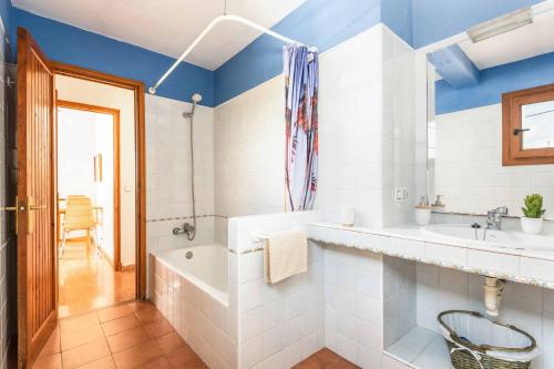 卡拉恩波特Villa Chiquita的带浴缸、两个盥洗盆和浴缸的浴室。