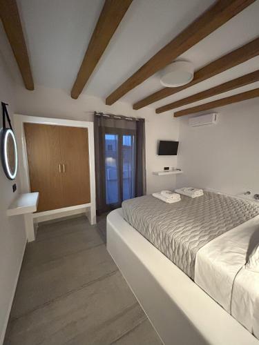 考弗尼西亚SOPHILIA SUITES的白色的卧室设有床和窗户