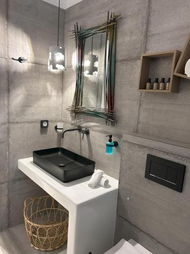 考弗尼西亚SOPHILIA SUITES的浴室设有黑色水槽和镜子