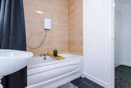 利物浦Stunning 3-Bedroom House Sleeps 8的浴室配有白色浴缸和水槽