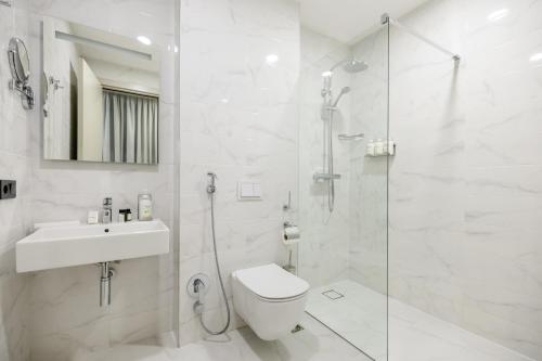 第比利斯Brosse Garden的带淋浴、卫生间和盥洗盆的白色浴室