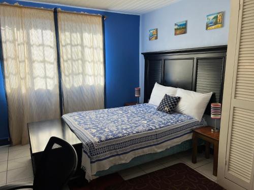 圣乔治Cool Running Apartments的一间卧室配有一张蓝色墙壁的床
