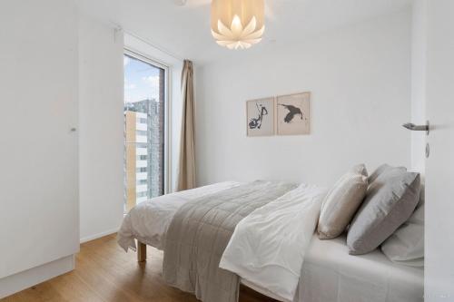奥胡斯Seaside apartment with magical balcony view的白色的卧室设有床和窗户