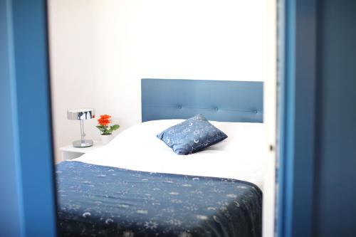 毕尔巴鄂Maestro Damián Moderno Apartamento a Estrenar en Bilbao的卧室配有白色床和蓝色枕头